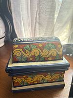 Front angle view of ceramic trinket box showing hand-painted Talavera floral scroll pattern and removable lid