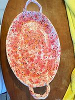 Full view of oval pink speckled ceramic platter with handles