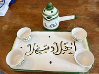 Complete tea set on table showing tray, teapot and four cups