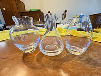 Front view of all three clear glass vases showing overall shapes and condition