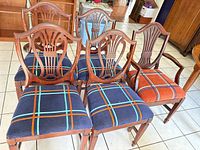 Front view five Hepplewhite shield back chairs showing upholstery colors