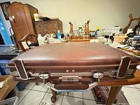 Front view closed briefcase on table showing overall size, color, handle, hardware