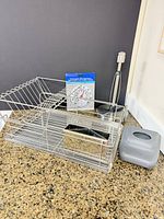 group shot of dish rack, paper towel holder, thermometer package and grey dispenser