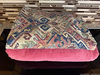 Both fabrics folded: geometric piece on top, pink terry beneath