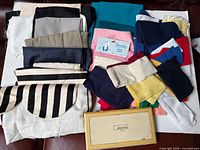 Pile of assorted coloured fabric pieces and closed Alpha 224 wooden case