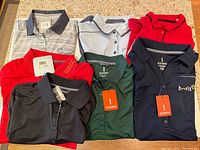 Seven polo shirts laid out displaying colours and tags