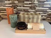 Group shot showing boxed candle, wood stand, green pillar, orange doorplate candle