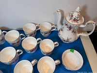 Coffee pot, several mugs, sugar bowl visible