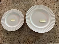 Stacked dinner and side plates showing size difference and gold rim