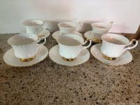 Six Royal Albert Val D'Or teacups on matching saucers, frontal view