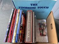 Box showing multiple sewing and craft books, embroidery thread pack and pattern