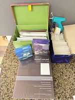 Group view of sealed Freeleaf notepad pack, boxes of greeting and thank-you cards, and tagging gun