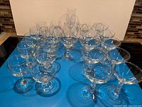 Group shot of all clear stemmed glasses on blue surface