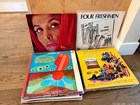 Stack of vinyl LPs with visible titles including Four Freshmen, Guitar Underground, Fire and Romance, plus others