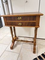Front view of wood side table showing drawers, legs, hardware