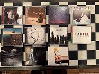 Front view of 11 CD cases showing album artwork