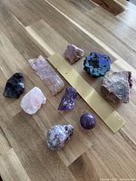 Nine mineral specimens laid out with 20 cm brass ruler for scale