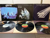 Three album covers and three records displayed