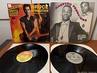 Lot overview showing two jackets (Bruce Springsteen, Maestro Fresh-Wes) and two vinyl discs