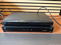 Sony DVD/CD player stacked on Bell receiver, both powered by cables