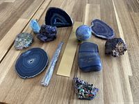 all eleven mineral specimens laid out on wood surface