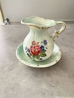 Pitcher on basin showing floral motif and gold trim