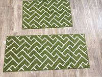 Front view of both green geometric rugs showing pattern and relative sizes