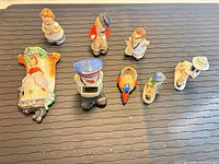 Eight small ceramic wall pocket figurines displayed face up