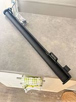 Retractable mesh gate rolled in black housing with hardware bag on countertop