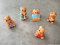 Front view of all five figurines on grey surface