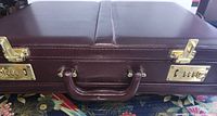front view of burgundy leather briefcase showing handle and combination locks