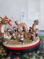 Front view of complete figurine set showing child figures, dragon and base