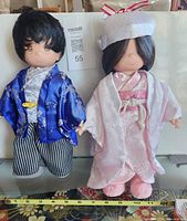 Front view of both dolls displaying outfits and scale tape