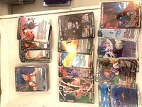 Stacks of Dragon Ball Super holo/foil cards spread out, showing quantity and variety