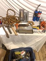 Overview of rope, hammers, trowels, propane cylinders, extension cord and tool box