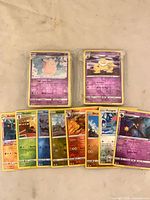 Two bundled stacks of reverse holo cards, top cards Clefairy evolutionary line and Slowpoke line visible