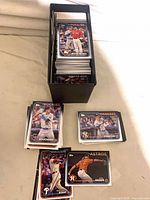 Box holding stack of baseball cards, several cards displayed