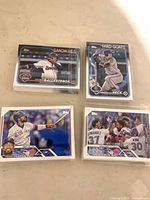 Four cellophane-wrapped stacks of Topps baseball cards, top cards visible include Ballesteros, Beck, Hernandez and Blue Jays team card