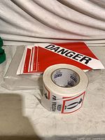 Roll of Keep Frozen labels with stack of Danger sign sheets