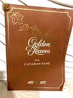Full view of brown poster with title, maple leaf graphics, dates 1867-1967
