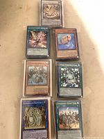 Eight stacks of sleeved Yu-Gi-Oh! cards, sample top cards visible