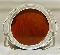 Full view of round aluminum tray with brown center and handles