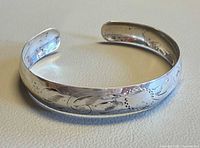 Top view of sterling silver open cuff bangle showing engraved swirl pattern