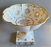 Overall view showing scalloped rim, gold decoration, pedestal base