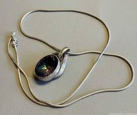Full view of silver snake chain and mystic topaz pendant