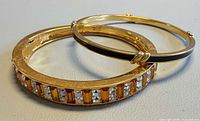 Overview of both bangles—rhinestone Butler and black enamel Monet