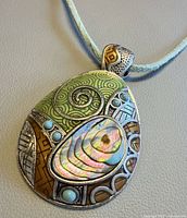 Front view of Lia Sophia abalone pendant on blue cord