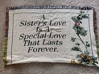 Full view of woven throw showing quote and floral design.