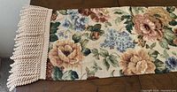 Full length view of woven floral tapestry runner with fringe