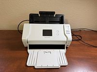 Front view of Brother ADS-2700W scanner with trays open and cords visible